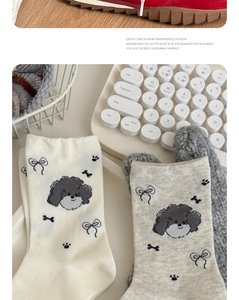 Detail of cute dog pattern cotton socks featuring black bows and soft paw prints