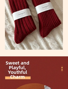 Detailed view of red chunky ribbed knit wool socks with branding label for winter wear