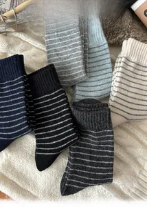 Flat lay of retro striped wool socks in vintage blue and grey tones on a knit blanket
