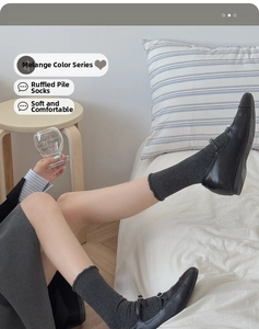 Detail of dark grey ruffled cotton socks paired with black Mary Jane shoes for a retro look