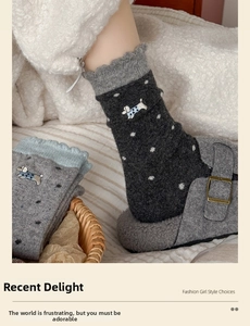 Detailed knit texture of wool socks with puppy embroidery and ruffled edges in grey