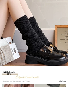 Detail of black knitted leg warmers with ribbed texture and Y2K aesthetic styling