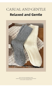 Detailed knit texture of thick grey and beige wool crew socks on a rustic table