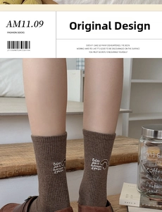 Detail von braunen Baumwollsocken mit süßer weißer Hundestickerei und gerippter Textur