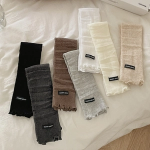 Slim knit leg warmers in various colors including black and grey with ruffled edges