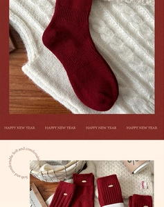 Macro detail of red wool socks featuring a gold metal buckle on the ribbed cuff