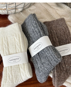 Detailed knit texture of wool socks in beige, dark grey, and coffee brown colors