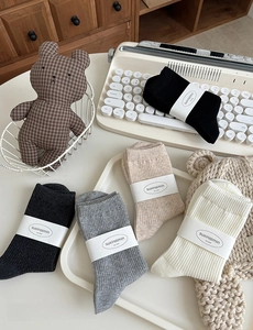 Detail von gerippten Stricksocken in neutralen Tönen mit minimalistischer Verpackung