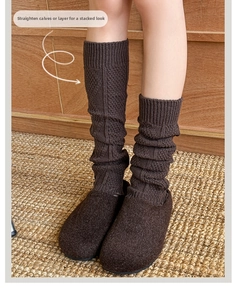 Detail of dark brown cable knit leg warmers showing textured diamond pattern and cozy fit