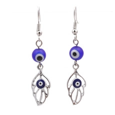 Detailed view of silver evil eye earrings with blue beads and leaf metal pendants