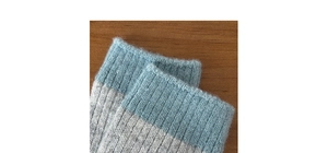 Detail of wool blend socks showing blue ribbed cuffs and soft fuzzy knit texture