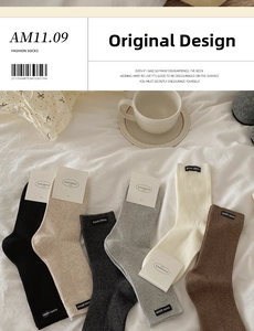 Detail of knitted cotton crew socks in earth tones featuring minimalist woven labels