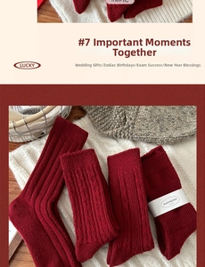 Detail of red wool knit socks with cable pattern and festive gift packaging bands