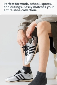 Detailed view of silver metallic sneakers with black stripes and grey cotton sports socks