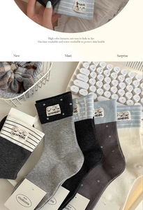 Detailed display of striped and polka dot cotton socks with handmade cartoon dog patches