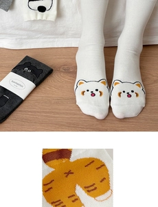 Detail view of cotton socks with a cute red panda face and striped tail pattern on the heel
