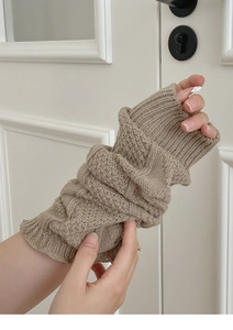 Close-up of khaki knit arm warmer showing detailed diamond pattern and soft texture