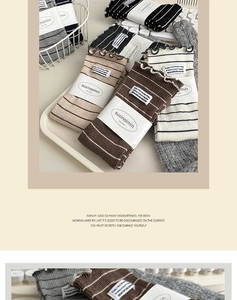 Detail of striped cotton socks with ruffled lettuce edge and chic brand cloth label