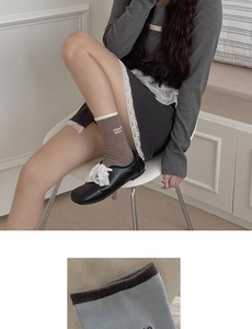 Detailed macro view of retro brown cotton socks with cream contrast cuff and Bebe embroidery