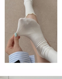Detail of white ruffle trim socks showing high elasticity and breathable mesh knit texture