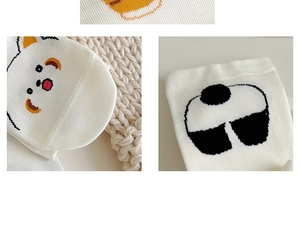 Detail of white cotton socks showing cute cartoon animal patterns and soft knit texture
