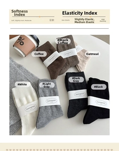 Detail of soft mid-calf cotton socks in neutral tones with ribbed cuffs and packaging