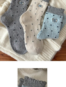 Detailed view of thick wool socks with dog embroidery and polka dots for winter