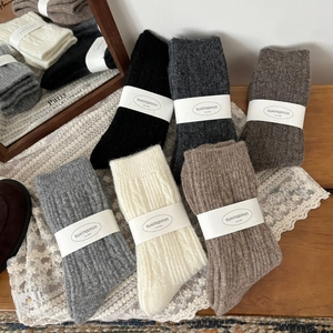 Thick wool twist-knit crew socks in assorted neutral colors with vertical ribbed texture