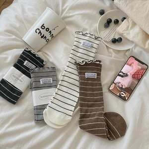 Japanese style striped crew socks with ruffled edges and fabric labels in four colors