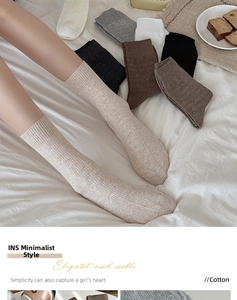 Detailed close-up of ribbed cotton socks with textured waffle pattern in neutral colors