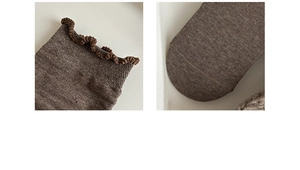 Detailed macro view of the delicate ruffle cuff and seamless toe of coffee cotton socks