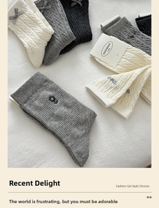 Detail of cable knit crew socks with grey ribbons and floral embroidery accents
