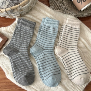 Three pairs of striped wool blend mid-calf socks in grey, blue, and cream colors