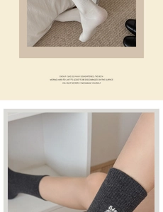 Detailansicht weißer und dunkelgrauer Rippstrick-Socken mit kleiner Hunde-Stickerei