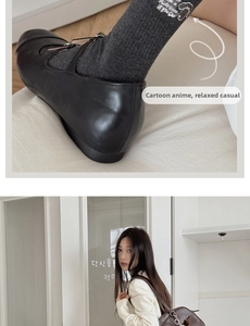 Detail der grauen Socken mit Hunde-Stickerei und schwarzen Vintage-Mary-Jane-Schuhen