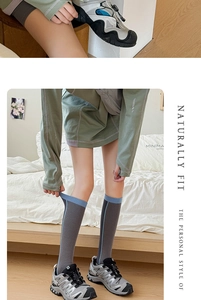 Detail of dark gray compression athletic socks with light blue stripes and snug cuffs