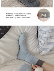 Detail of light blue cotton crew socks with grey ribbed cuffs and a cute mouse woven label