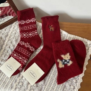 Tre paia di calze invernali festive in lana rossa con renne e fiocchi di neve