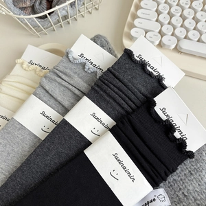 Set of four cotton knit ruffle socks in white grey and black with floral trim