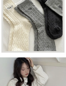 Close-up of cable knit socks with flower embroidery and quilted jacket detail