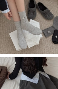 Detail of speckled cotton socks featuring a cute lamb embroidery and soft ribbed texture