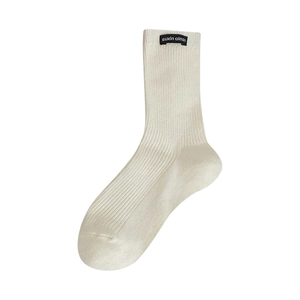 Off-white mid-calf socks with vertical rib knit texture and black woven label detail