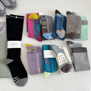 Variety of athletic compression socks in assorted colors with star patterns and logo packaging