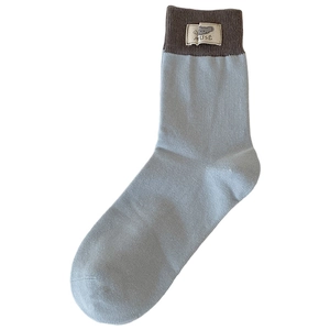Light blue mid-calf ribbed knit sock with cartoon mouse tag and Muse logo label