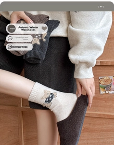 Detail of wool socks showing cute cartoon dog flocking and warm knit texture