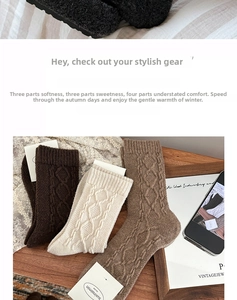 Close-up of three pairs of wool socks featuring cable knit patterns in earthy brown and cream