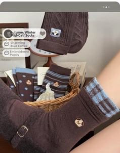 Detail of embroidered puppy on brown and blue mid-calf socks for autumn and winter