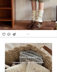 Detail of cream and grey ribbed knit leg warmers featuring woven square cloth labels