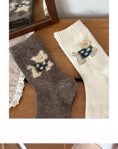 Detailed close-up of wool socks featuring 3D plush dog patch with star pattern
