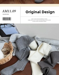 Detailed view of thick knit over-the-knee socks in grey and cream with ribbed texture